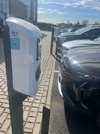 Laadpaal op paal op een parking met wagens