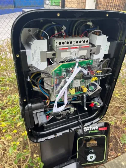 Opengemaakte laadpaal met de elektronica zichtbaar